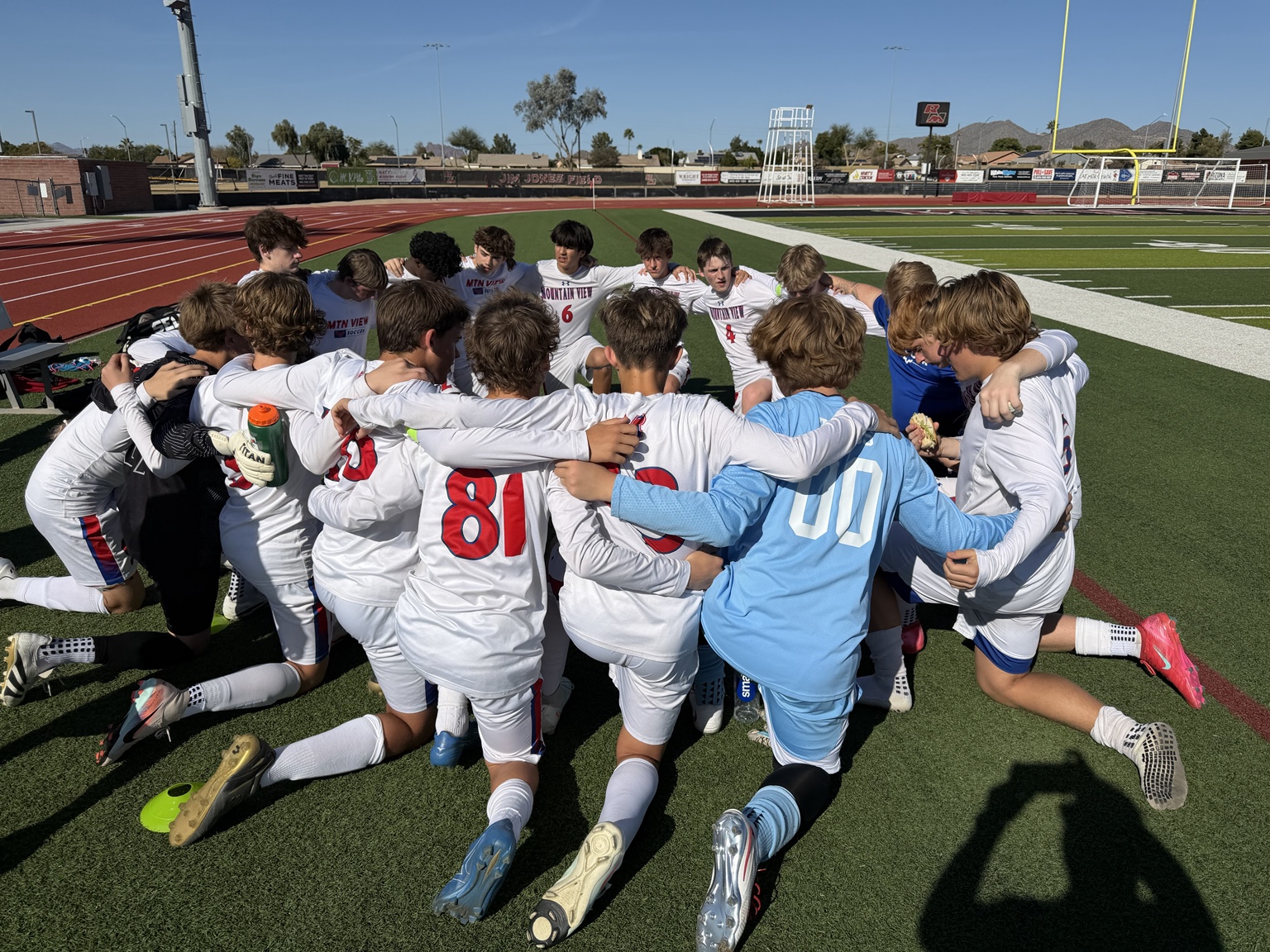 Mountain View boys soccer team gathered in a huddle