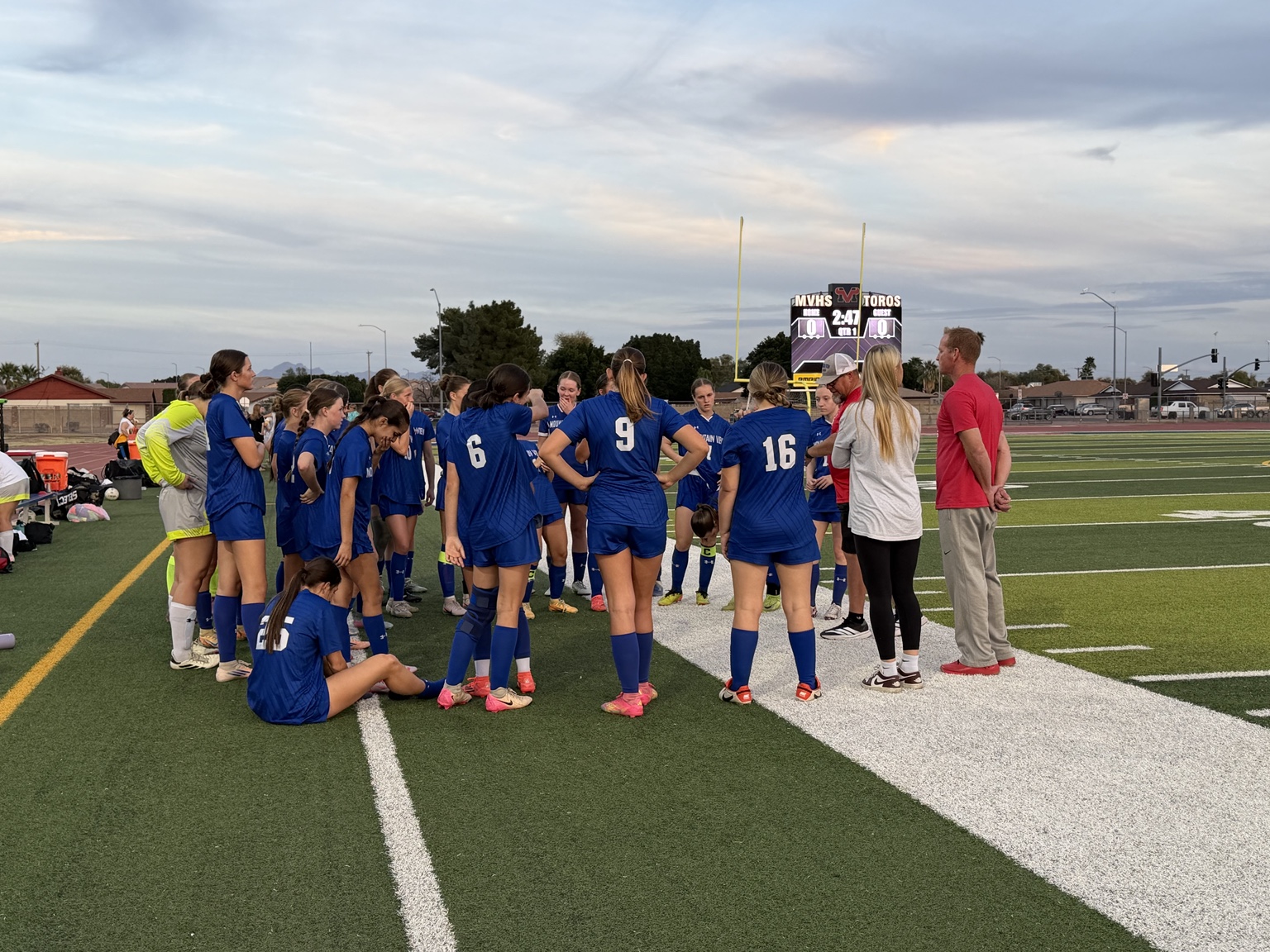 Mountain View girls soccer team meeting with coaches on the sideline